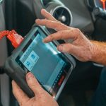 person holding blue diagnostic tool