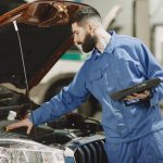 mechanic checking the engine of a car