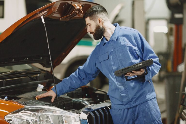 mechanic checking the engine of a car