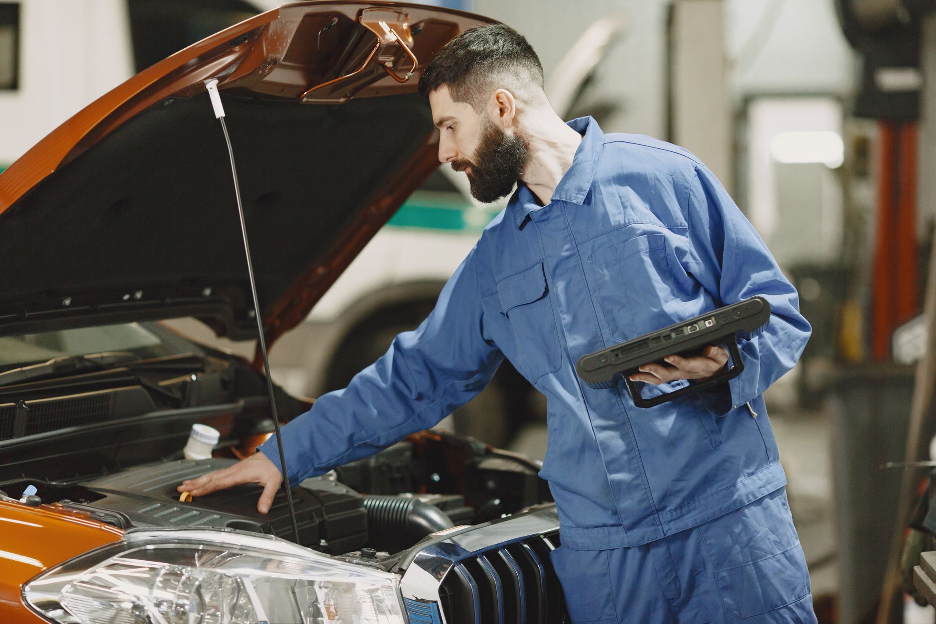 mechanic checking the engine of a car