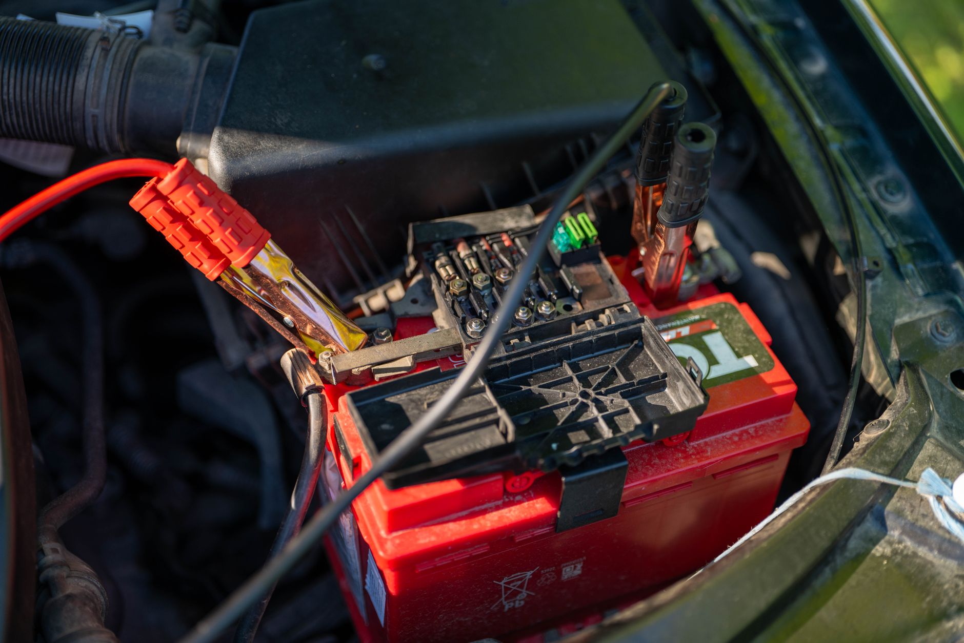 car battery with jumper cables in engine bay